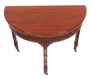A Chippendale Revival mahogany demi lune foldover card table, with a green baize interior, above...