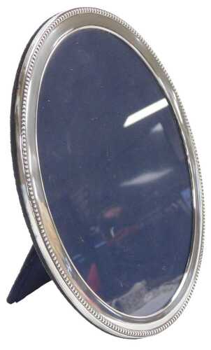 An Elizabeth II silver back strut photograph frame, of oval form, with a beaded rim, Birmingham...