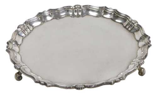 A George V silver piecrust salver, raised on three scroll feet, Sheffield 1912, 11.12oz.