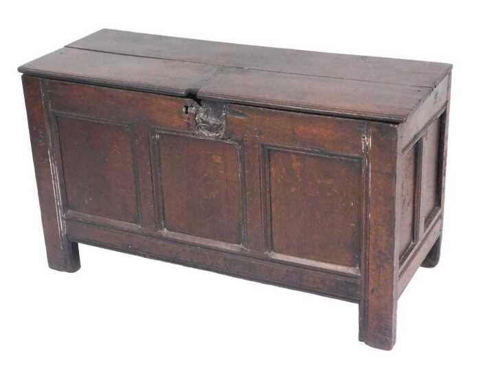 An 17thC oak coffer, with a two plank top, above a triple panelled front, raised on stiles, 65cm...