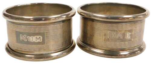 A pair of Elizabeth II silver napkin rings, with engine turned decoration, rectangular reserves...