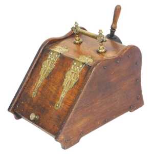 A Victorian oak coal scuttle, with brass strapwork and carrying handle, the hinged lid opening...