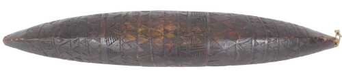 A tribal canoe shaped shield, decorated overall with geometric carving in bands, possibly...