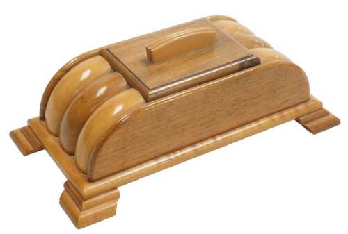 An Art Deco walnut cigarette box, of domed and fluted form, raised on a rectangular base and...