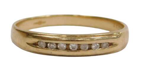 A 9ct gold and diamond half hoop eternity ring, set with seven brilliant cut diamonds, in a rub...