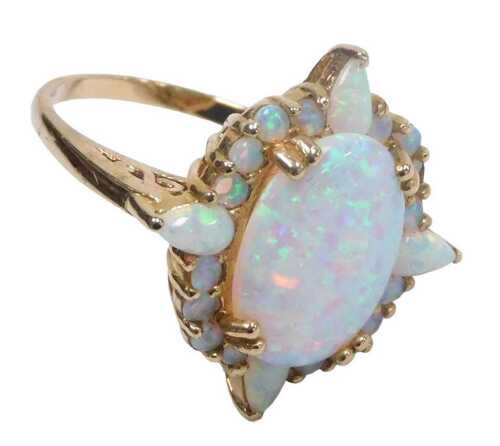 A 9ct gold and opal ring, the central oval cabochon opal, in a surround of circular and tear...
