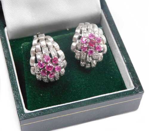 A pair of ruby and diamond flowerhead and basket weave curved earrings, in white metal,...