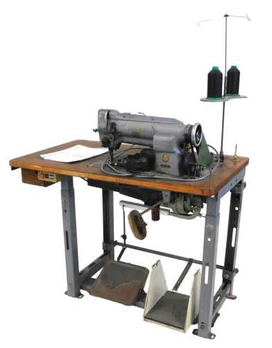 A Singer industrial sewing machine, model number 211 G 155, in grey, on a trestle base, with...