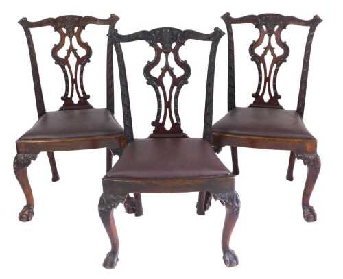 A set of three George III style mahogany dining chairs, each with a pierced splat, a brown drop...