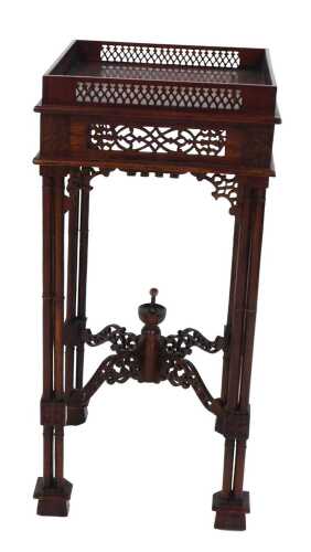 A Chippendale style mahogany urn stand, the square top with a pierced gallery, above a pierced...
