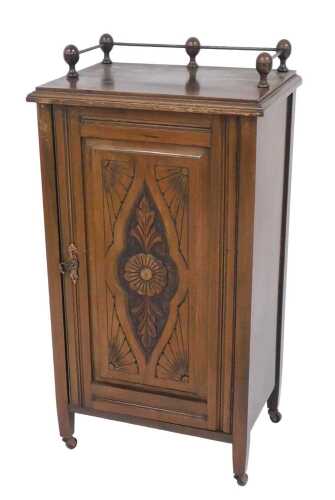 A late 19th/early 20thC walnut music cabinet, the top with a three quarter brass gallery and a...