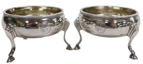 A pair of George III silver circular salts, with a beaded rim, raised on three hoof feet, London...