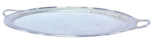 An Edward VII silver twin-handled tray, of oval form, with leaf decoration to each handle, and...