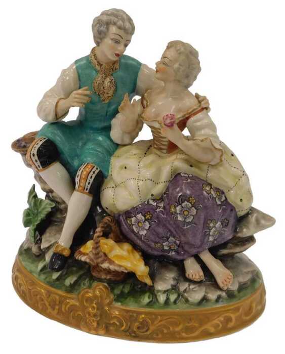 A 20thC Meissen porcelain figure, modelled as a lady and gallant in 18thC dress, in a seated...