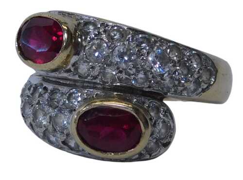 A 9ct gold garnet and cz crossover ring, the oval garnets in a rub-over setting, with pave-set...