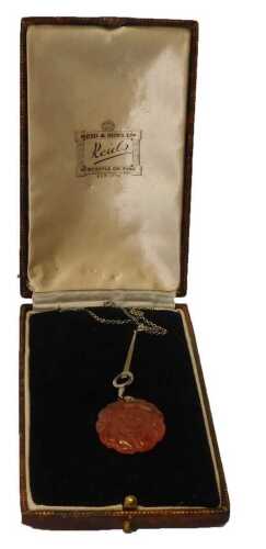 An early to mid 20thC Art Deco style pendant and chain, the pierced orange agate flower, mounted...