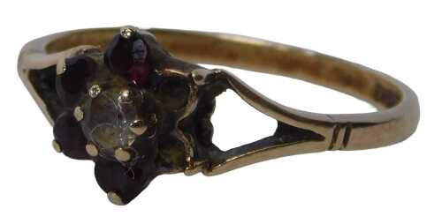 A 9ct gold garnet cluster ring, set with a six stone design, with four garnets, and a centre cz...