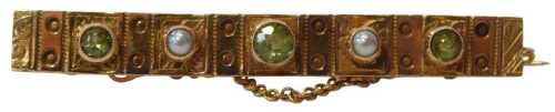 A Victorian 9ct gold bar brooch, of panelled and etched floral design, set with three peridots...