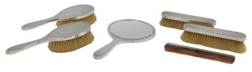 An Elizabeth II six-piece silver-mounted dressing table set, comprising two hairbrushes, two...