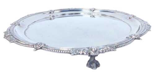 A George V silver salver, with a beadwork border interspersed with flower heads, scrolling and...