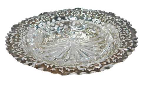 A late Victorian silver butter dish, of circular pierced and embossed form, with a cut glass...