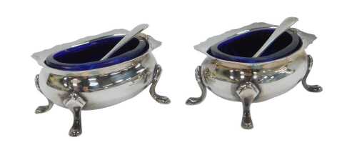 A pair of George V silver open salts, each with a piecrust rim, of bellied form, raised on four...