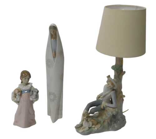 Three pieces of Lladro porcelain, comprising a table lamp modelled as a huntsman beside a dog,...