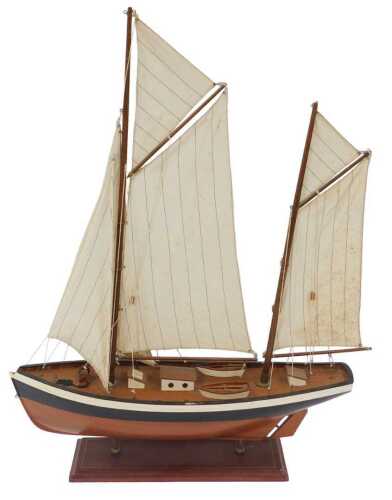 A wooden model of a sailing barge, with fabric sails, mounted on a stepped wooden base, 80cm high.
