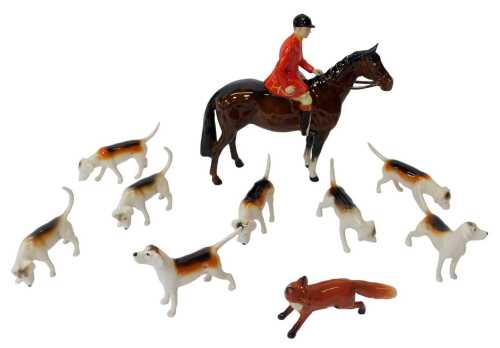 A Beswick hunting group, comprising a huntsman on horseback, 21cm high, a fox, together with...