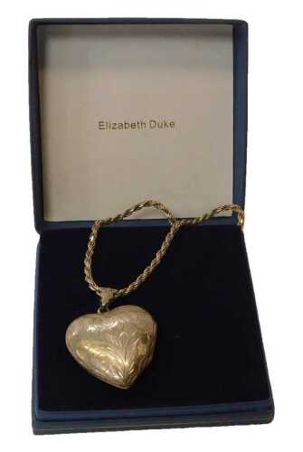 A silver pendant and chain, the heart-shaped locket with an engraved floral design, 3.5cm high,...