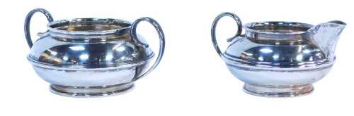 A George V silver cream jug and sugar bowl, each with a ribbed central band, Birmingham 1931,...
