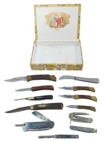 A group of folding pocket knives, to include some with wooden handles, one with a simulated horn...