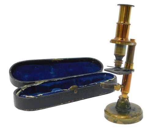 A late 19thC French travelling microscope, 14cm high, with attachment, contained in a leather case.
