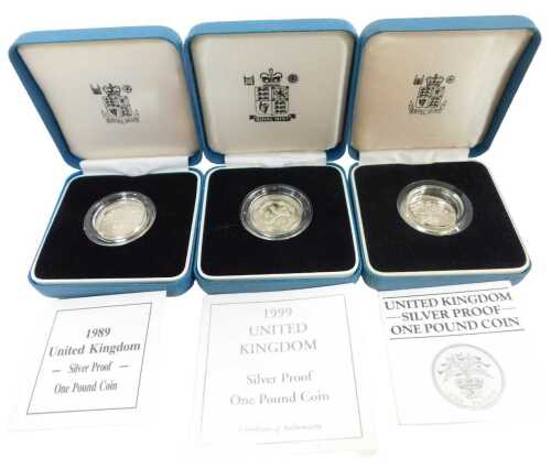 Three Royal Mint silver proof one-pound coins, for 1984, 1989, and 1999, each boxed with a...