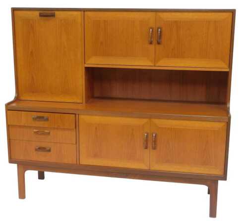 A G-Plan teak side cabinet, the top with two doors and a fall front door, the base with three...