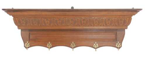 A 20thC carved oak coat rack, the moulded cornice with a leaf carved frieze, above three brass...