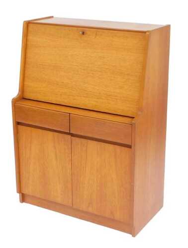 A Remploy teak bureau, the fall front enclosing a fitted interior, above two drawers and two...