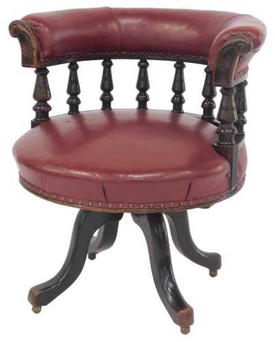 A Victorian mahogany library chair, upholstered in ox blood red leather, with scroll carved...