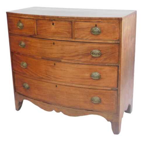 An early 19thC mahogany and boxwood strung bow fronted chest of drawers, with an arrangement of...