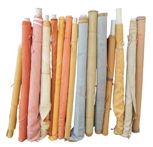 Various bolts of upholstery fabric, differing designs, predominantly yellows and reds. (a quantity)