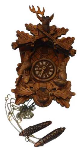 A Schneider carved wooden cuckoo clock, with a Roman numeric dial, the case surmounted by a stag'...