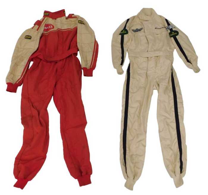 An OMP racing suit and a Jays racing suit, with various applied patches including Dunlop, Rolex...