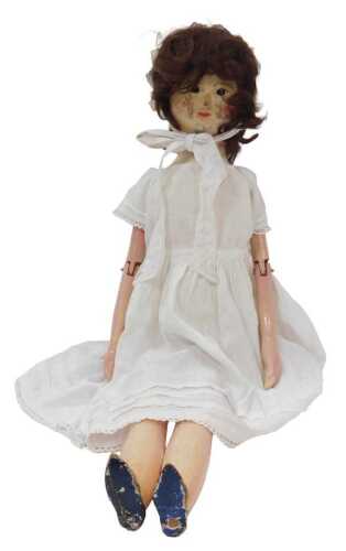 A wooden articulated doll, wearing a dress and bonnet, 67cm high.