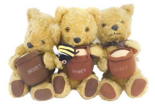 Three Chad Valley Winnie the Pooh plush bears, each in the seated position holding a pot of...