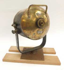 A brass ship's spotlight, mounted on a wooden plinth. - 2