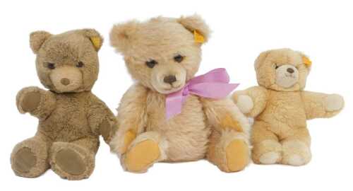 A Steiff pale coloured plush bear, with pink ribbon, button to ear and cloth tag, 30cm high, and...