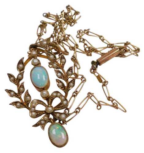 An Edwardian opal and seed pearl pendant, of wreath and tied bow form, unmarked, on a neck chain...