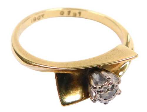 A diamond solitaire ring, in a cross over setting, yellow metal stamped 18ct, size M, 3.3g all in.