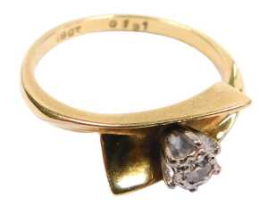 A diamond solitaire ring, in a cross over setting, yellow metal stamped 18ct, size M, 3.3g all in.