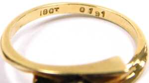 A diamond solitaire ring, in a cross over setting, yellow metal stamped 18ct, size M, 3.3g all in. - 3